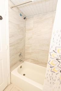 a bathroom with a tub and a shower at Mins to NYC! Urban Oasis 2-BR home with King & Queen Beds in Jersey City