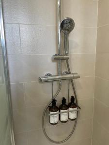 una ducha con 3 botellas en una cabina de ducha en Ritual Sevilla, Fedriani, en Sevilla