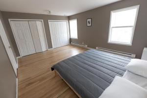 a bedroom with a large bed and two windows at Mins to NYC! Urban Oasis 2-BR home with King & Queen Beds in Jersey City