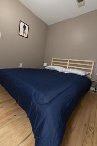 a bedroom with a bed with a blue blanket at Mins to NYC! Urban Oasis 2-BR home with King & Queen Beds in Jersey City