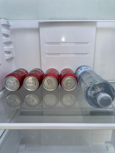 a refrigerator with a bottle of water and cans at Ritual Sevilla, Fedriani in Seville