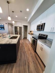 a large kitchen with white cabinets and wooden floors at Red Rock Suite - Castle Rock Condos in Richfield