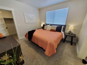a bedroom with a bed with an orange blanket and a window at Red Rock Suite - Castle Rock Condos in Richfield