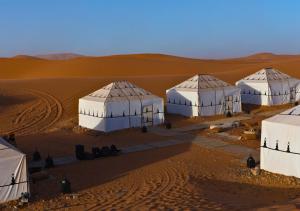 an overhead view of four domes in the desert at Sahara Berber Camp in Zagora