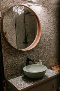 ein Badezimmer mit einem Waschbecken und einem Spiegel auf der Theke in der Unterkunft Csongor Lak in Igricetanya