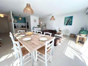 a dining room and living room with a table and chairs at VILLA SOWA - Maison avec piscine 850m océan in Mimizan +11 photos