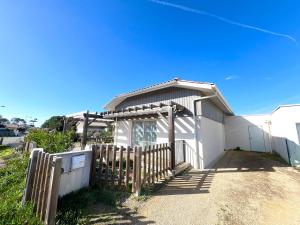 a white house with a wooden fence in front of it at VILLA SOWA - Maison avec piscine 850m océan in Mimizan