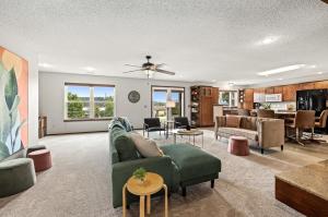 a living room with a green couch and a table at Hillside Hideaway - Lake Access - Hot Tub in Rogers