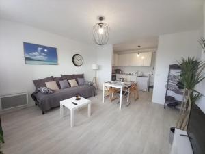 uma sala de estar com um sofá e uma mesa em St-Quentin-en-Yvelines Plusieurs appartements avec parking em Trappes