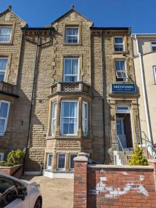 un gran edificio de ladrillo con un cartel. en Greystones, en Skegness