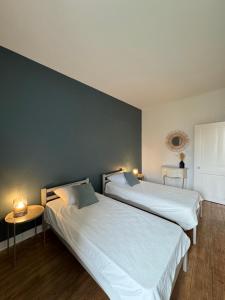 two beds sitting next to each other in a room at Le Hêtre Pourpre in Bayeux