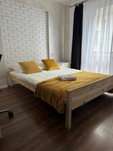 a bedroom with a large bed with yellow pillows at Apartamenty Dworcowe Stacja Centrum Kielce in Kielce