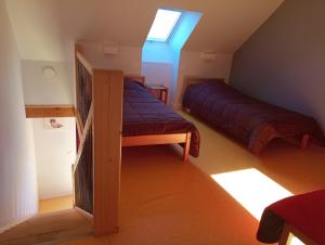 a attic bedroom with a bed and a window at Gîte de la Borie de Pourtou in Condat