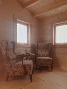 due sedie in una stanza con due finestre di Le Cottage OneHeart a Saverne