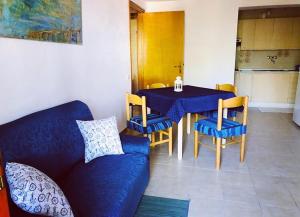 een woonkamer met een blauwe bank en een tafel en stoelen bij Appartamenti "LE CASETTE DI TERESA" in Ortona