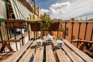 mesa de madera con 2 tazas en la parte superior de un balcón en Hotel Dell'Urbe, en Roma