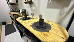 a wooden table with a hat and wine glasses on it at 21- Studio com decoração linda in Curitiba