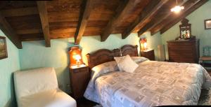 una camera con un grande letto e una sedia di Le Primule a Piedilago