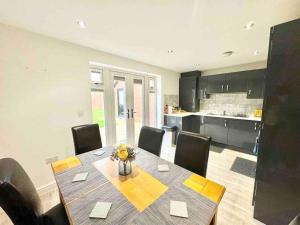 a dining room with a table and chairs and a kitchen at Folkestone 3 Bedroom Home just off M20, great area in Kent