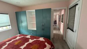 Schlafzimmer mit einem Bett und blauen Schränken in der Unterkunft Flamingo Tiny Home in Sarasota