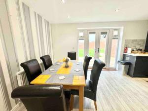 a dining room with a table and black chairs at Folkestone 3 Bedroom Home just off M20, great area in Kent