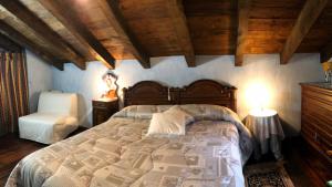 um quarto com uma cama grande e uma cadeira em Le Primule em Piedilago