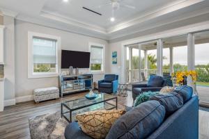 a living room with a blue couch and a tv at Modern Keys by Brightwild-Waterfront w Dock in Key West