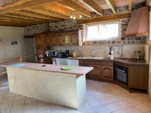 a kitchen with wooden cabinets and a large counter top at Le Petitepinay Chambres et Gîte in Moitron-sur-Sarthe