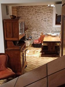 a kitchen with a table and a stone wall at Agriturismo San GIovanni Ad Insulam in Isola del Gran Sasso dʼItalia