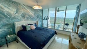 a bedroom with a blue bed and a large window at 09I Jungle/Ocean View to thrill Nature Enthusiasts in Panama City +49 photos