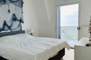 ein Schlafzimmer mit einem Bett und einem großen Fenster in der Unterkunft Face à la mer immense in Cayeux-sur-Mer