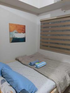 een bed in een kamer met een raam bij Shell Residences condotel Staycation in Manilla