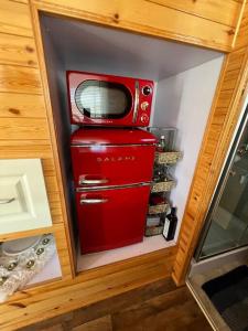 a small red refrigerator with a microwave on top of it at Tiny House - mountain views close to everything in Valley Center