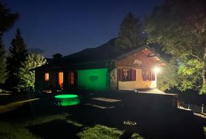 una casa iluminada por la noche con luz verde en B&B Le Petit Vent, en Sormano