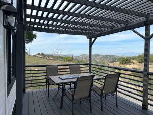 a patio with a table and chairs on a deck at Tiny House - mountain views close to everything in Valley Center