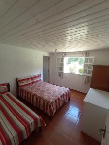 een slaapkamer met 2 bedden en een raam bij Chácara São José in Piranguçu