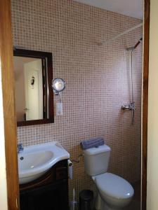 ein Badezimmer mit einem WC, einem Waschbecken und einem Spiegel in der Unterkunft Finca Caracol in Bolulla