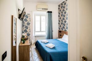 Un dormitorio con una cama azul y una ventana en Hotel Dell'Urbe, en Roma