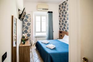 a bedroom with a blue bed and a window at Hotel Dell'Urbe in Rome