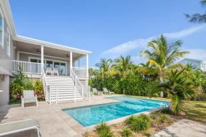 a villa with a swimming pool in front of a house at Smooth Sailing by Brightwild-Pool & Boat Dock in Key West
