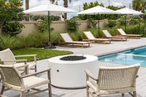 キーウェストにあるThe Ebberly House - Amazing Pool in Gated Communityのプールの横にある椅子と焚き火台
