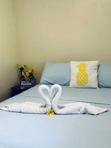 Hotel Las Hamacas في سانتا كاتالينا: سرير مع منشفتين على شكل قلوب