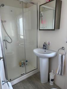 a white bathroom with a shower and a sink at D34 in Steeple