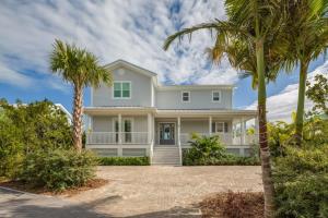 a white house with palm trees in front of it at Coastal Bliss by Brightwild-Pool, Parking, Dock! in Key West