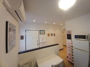 een witte kamer met een koelkast en een raam bij Casa Rolecca - Nel Cuore di Rapallo in Rapallo