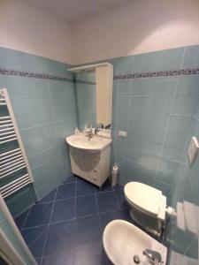 bagno con servizi igienici bianchi e lavandino di Casa Rolecca - Nel Cuore di Rapallo a Rapallo