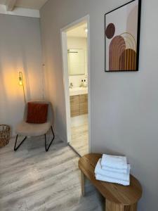 Cette chambre comprend une chaise, une table et un miroir. dans l'établissement High Street Apartments, à Zandvoort