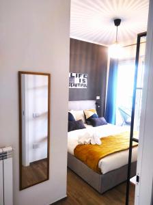 1 dormitorio con cama y espejo en Michelangelo Airport Suite Room en Fiumicino