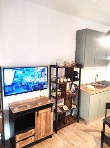 a living room with a flat screen tv and a kitchen at Michelangelo Airport Suite Room in Fiumicino