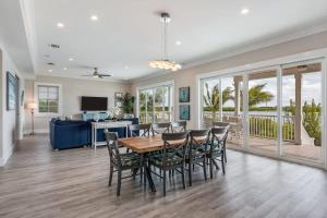 a dining room and living room with a table and chairs at Sophisticated Sunsets by Brightwild-Pool & Dock! in Key West